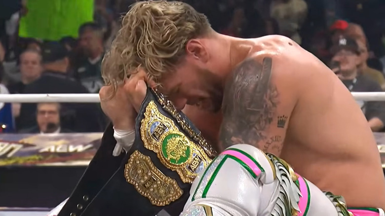 Ospreay celebrates with the AEW World Championship after surviving Clockwork Carnage.
