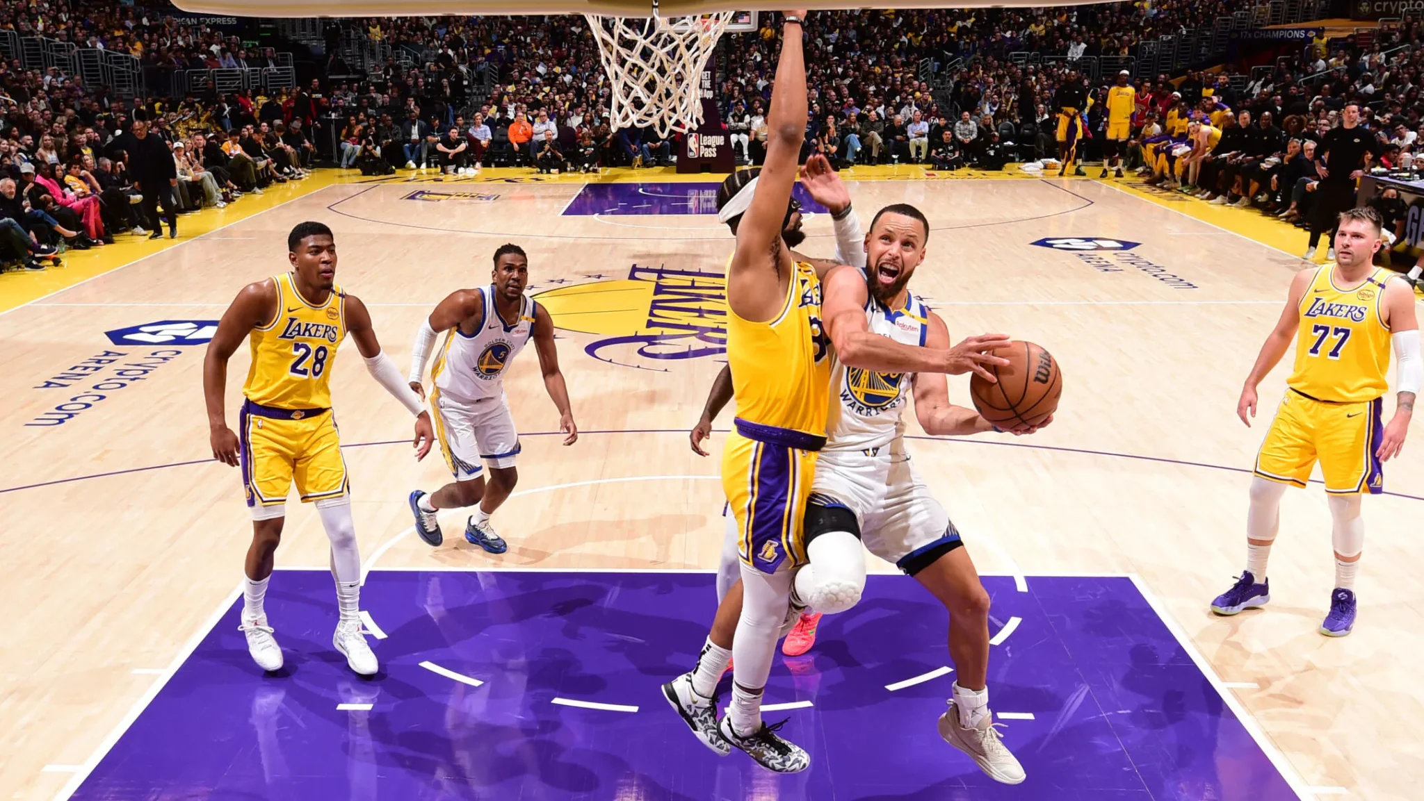 Stephen Curry drives to the basket against the Los Angeles Lakers with Luka Doncic defending during an earlier Lakers-Warriors meeting at Crypto.com Arena.