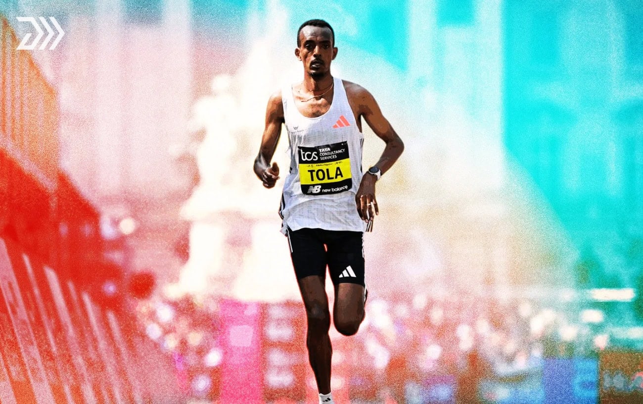 Tamirat Tola in action during a marathon race, wearing his 'TOLA' race bib