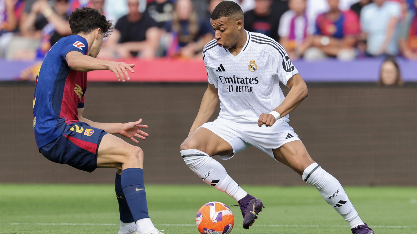 Kylian Mbappé on the ball for Real Madrid against a Barcelona defender