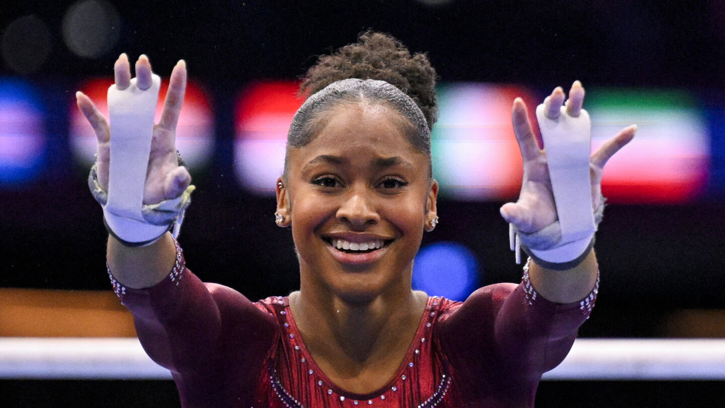 Skye Blakely smiles and raises her hands after uneven bars at the Rotterdam world championships