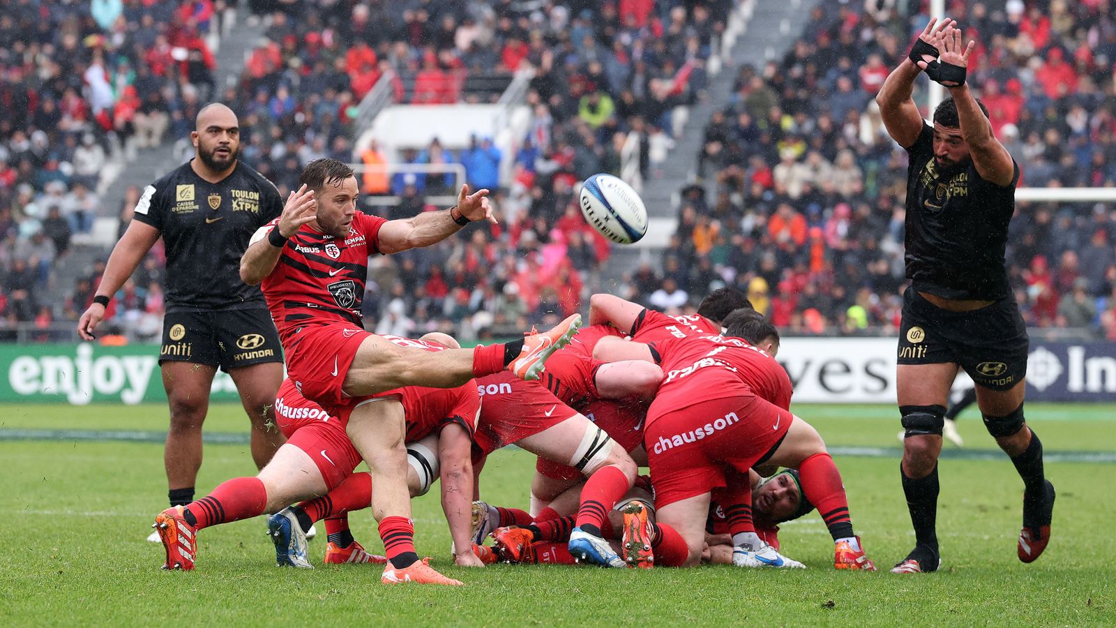 Stade Toulousain players in red charging down a ball against RC Toulon in Champions Cup action