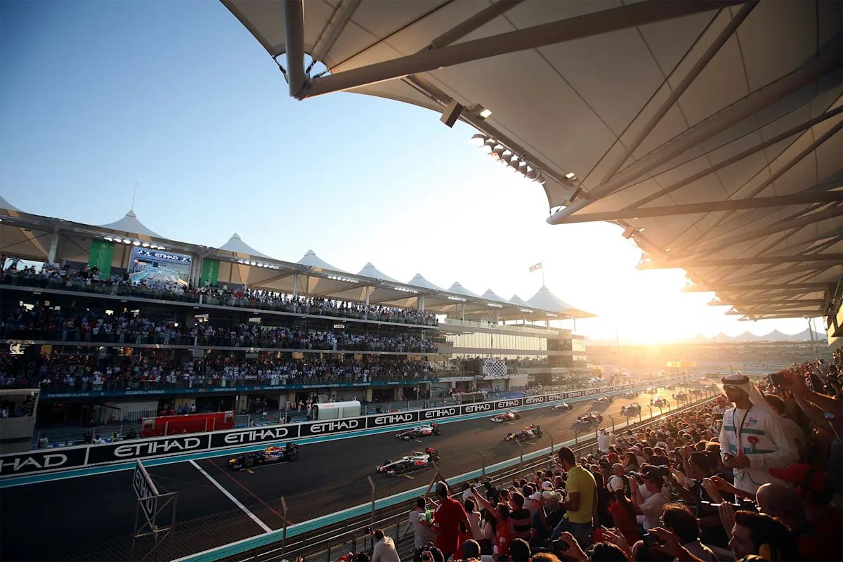 File photo: F1 cars on the main straight at Yas Marina Circuit in Abu Dhabi at sunset, with packed grandstands.