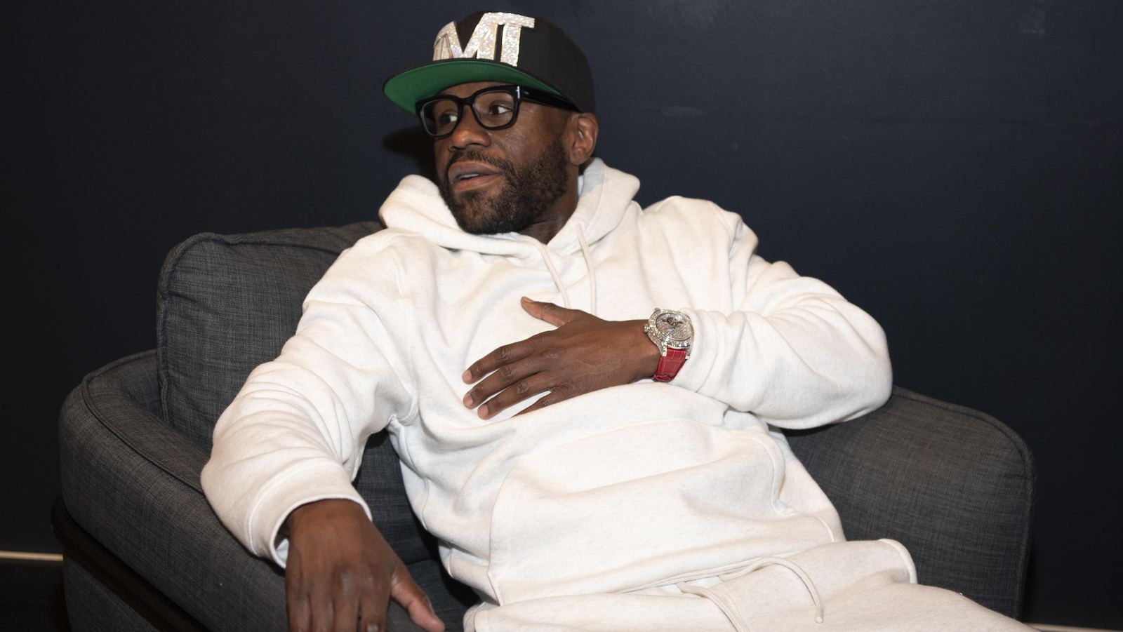 Floyd Mayweather photographed at an event in October 2026, wearing a white hoodie, glasses and a TMT cap