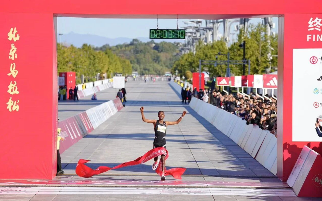 The winner breaks the finish tape at the 2026 Beijing Marathon at the Olympic Park finish