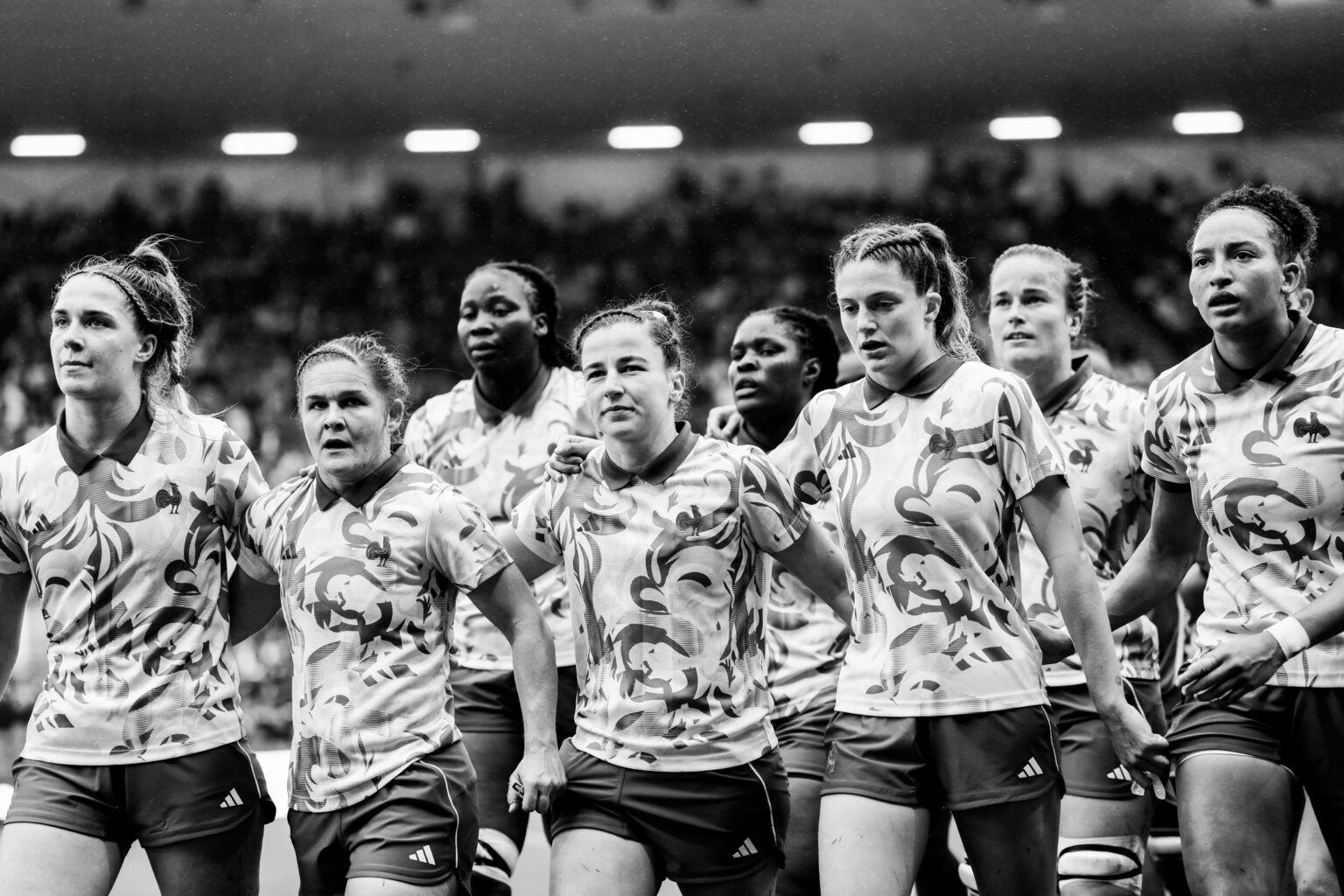 France women's players walk off together with arms around each other in a black-and-white shot from the 2025 Rugby World Cup